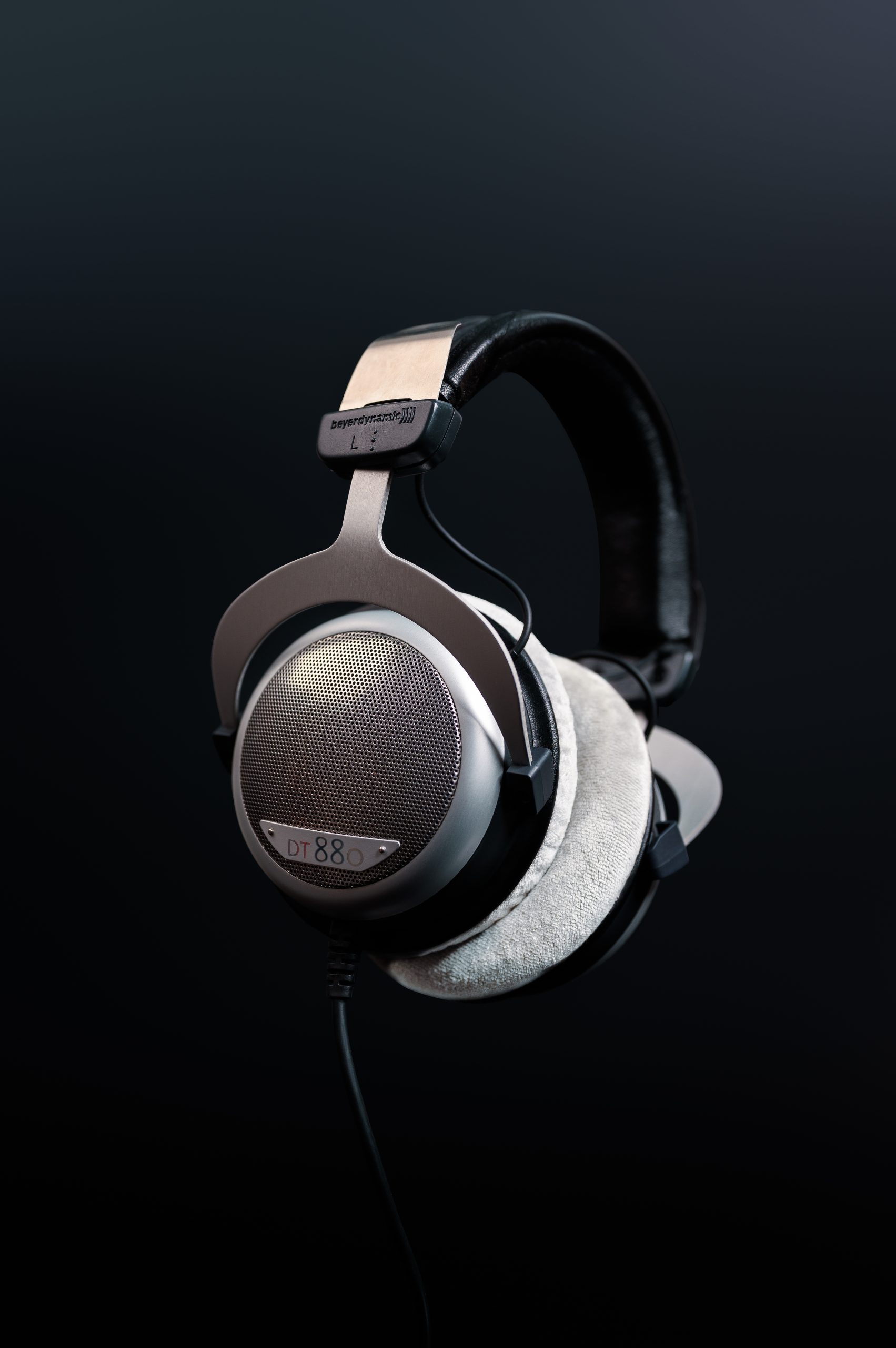 Studio portrait of Beyerdynamic DT 880 headphones with soft focus on textured earpads and grill.