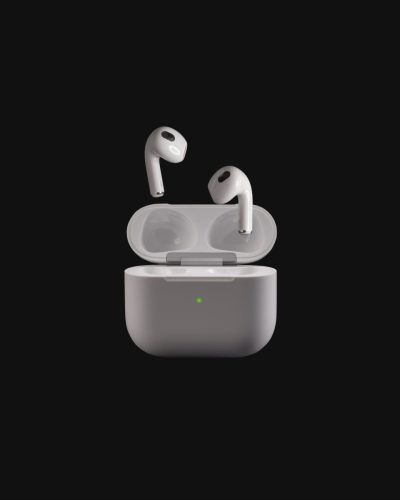 Apple AirPods floating above their open charging case on a deep black background with soft lighting.